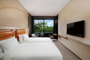 a hotel room with two beds and a flat screen tv at WM Hotel Hong Kong, Vignette Collection in Hong Kong
