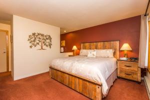 a bedroom with a bed and a tree on the wall at Willows 1713 in Keystone