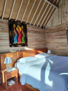 une chambre avec deux lits et un tableau au mur dans l'établissement Octopus Homestay, à Uluwatu