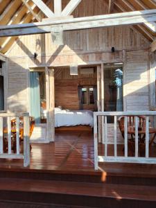 - une chambre avec un lit sur une terrasse en bois dans l'établissement Octopus Homestay, à Uluwatu
