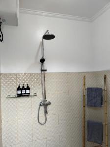 La salle de bains est pourvue d'une douche et de serviettes bleues. dans l'établissement Octopus Homestay, à Uluwatu