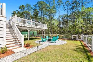 un patio con sillas azules y una escalera en Barefoot Bayou, en Santa Rosa Beach