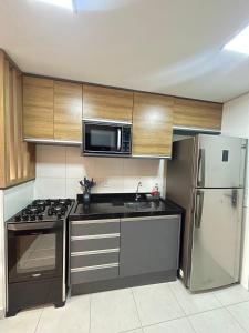 eine Küche mit einer Mikrowelle und einem Kühlschrank in der Unterkunft #1 Apto TOP próx Metrô-Allianz Parque-Pró Magno in São Paulo + 22 Fotos