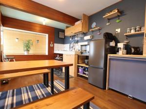 a kitchen with a table and a stainless steel refrigerator at Greenmist Atami with Onsen in Atami