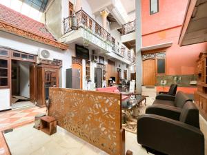 a living room with a couch and chairs in it at RedDoorz Syariah Near Alun-Alun Tulungagung in Tulungagung