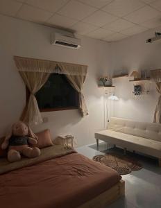 a bedroom with a teddy bear sitting on a bed at Gờ Home Phan Thiết in Ấp Sung Xuân
