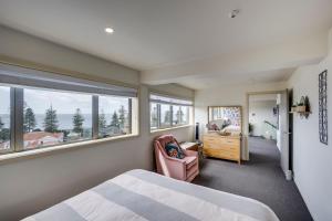 a bedroom with a bed and a desk and a window at Seabreeze Penthouse - Napier Holiday Apartment in Napier