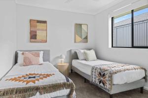 una camera da letto con due letti e una finestra di Time Out Beautifully decorated new home a Cessnock Altre 35 foto