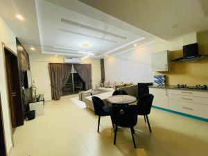 a kitchen and a living room with a table and chairs at 1 Bedroom 1BHK Elegant Secure & Luxury Apartment in islamabad in Islamabad
