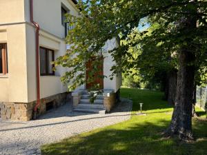 a building with stairs and a tree next to it at Dom na Słowiańskiej in Szczawno-Zdrój