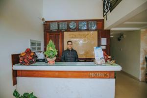 een man die achter een balie staat in een restaurant bij Thanh Loan Hotel DL - by BAY LUXURY in Da Lat