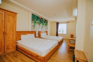 een slaapkamer met twee bedden en een schilderij aan de muur bij Thanh Loan Hotel DL - by BAY LUXURY in Da Lat +12 foto's
