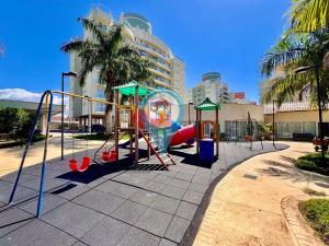 un parque infantil frente a un edificio con palmeras en N1401 VISTAMAR Amplo Club Praia Beto Carrero 4qrts, en Penha