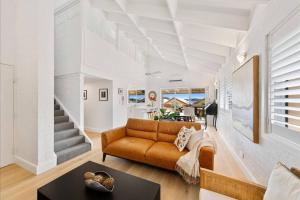 una sala de estar con un sofá y una mesa en Magical Hardy's Bay Waterfront Apartment, en Killcare