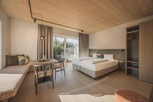 a bedroom with a bed and a desk and a table at SOLU Apartments in Seefeld in Tirol