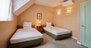 ein Zimmer mit zwei Betten und einer grünen Tür in der Unterkunft Forest Villa Huis Ten Bosch in Sasebo