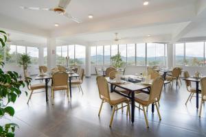 a dining room with tables and chairs and windows at Regent Heights in Kandy