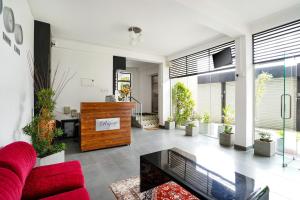 a living room with a red couch and some plants at Regent Heights in Kandy +7 photos