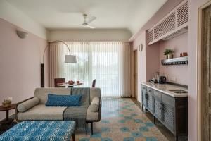 a living room with a couch and a kitchen at Kshemavana The Wellness Retreat in Bengaluru