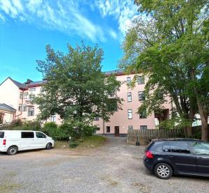 two cars parked in a parking lot in front of a building at Valoisa läpitalon kaksio in Porvoo