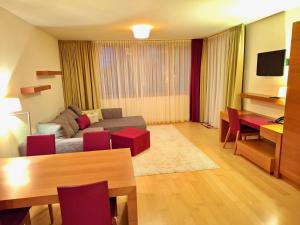 un soggiorno con un divano e un tavolo di WHIRLPOOL-SUITE AMADEUS - Weitblick - Golf & Wellness - direkter Bademantelgang - ADULTS ONLY a Bad Waltersdorf