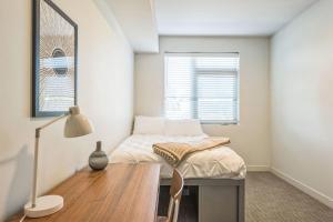 a bedroom with a bed with a desk and a window at Chic and Modern Getaway with Gym 5 Min to Downtown in Boise