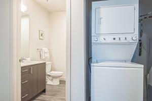 a white bathroom with a toilet and a sink at Chic and Modern Getaway with Gym 5 Min to Downtown in Boise