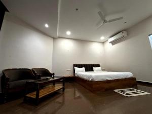 a bedroom with a bed and a couch and a table at Rupmati The Valley Hotel in Māndu
