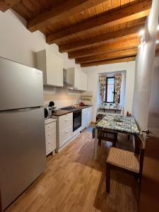 a kitchen with a stainless steel refrigerator and a table at Fikus APT relax Castello Ursino in Catania