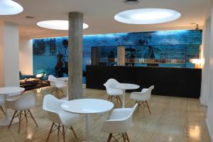 un restaurante con mesas blancas y sillas blancas en Rochester Hotel Classic, en Buenos Aires