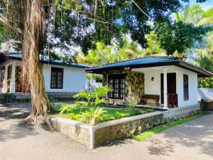 a white house with a tree in front of it at Villa de Galle in Galle