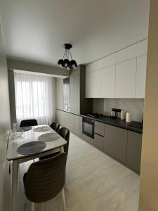 a kitchen and dining room with a table and chairs at Lux Apartament Center in Chişinău
