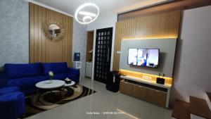a living room with a blue couch and a tv at Villa Naratetama in Batu