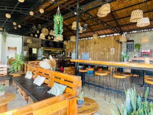 a restaurant with wooden benches and a bar with plants at MAAYONG HOSTEL in Moalboal