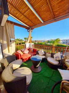 a patio with a couch and chairs on a green rug at 2 Bedroom apartment on luxury delta Sharm resort in Sharm El Sheikh