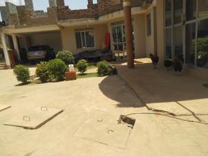 a house with chickens walking in front of it at Biocity Home Kampala in Kampala