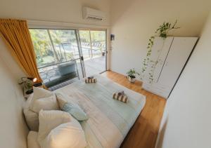 un grande letto in una stanza con una grande finestra di Byron Yoga Centre a Byron Bay Altre 21 foto