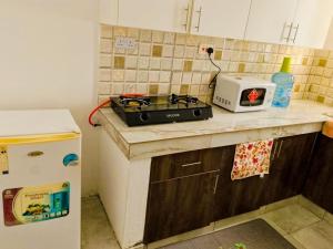 a kitchen counter with a stove and a toaster on it at Marty's Apartment in Mombasa +7 photos
