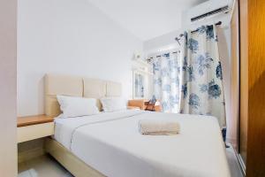 Ένα ή περισσότερα κρεβάτια σε δωμάτιο στο Homey and Elegant Studio Amazana Serpong Apartment By Travelio +8 φωτογραφίες