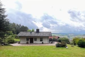 una piccola casa bianca su un campo verde di Vintage Haus AUF DEM HEIDCHEN mit Sauna a Knüllwald