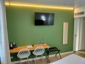 a room with a desk with two chairs and a television on the wall at Le Château in Tournon-sur-Rhône +18 photos