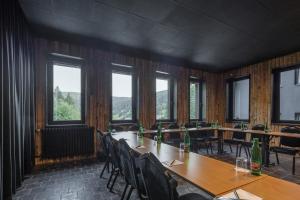 a dining room with tables and chairs and windows at Pytloun Wellness Hotel Harrachov in Harrachov