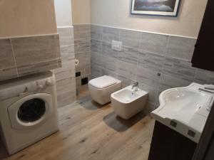 a bathroom with a toilet sink and a washing machine at Trilocale con vista La Grandze Cir164 in La Salle