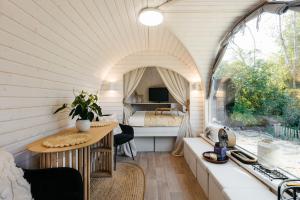 a room with a table and a bed in a room at La CABANE LUXUEUSE AVEC JACUZY in Lavacherie