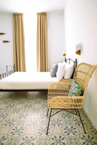 a bedroom with a large bed and a chair at VOLPE E UVA Winesuites & Spa in Trani +39 photos