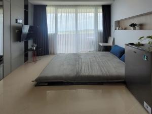 ein Schlafzimmer mit einem großen Bett und einem Fernseher in der Unterkunft Apartment Nuvasa Bay Nongsa, Kalani 1BR 12th, Sea & Golf View in Telukmataikan + 25 Fotos