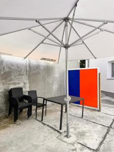 a table and two chairs under a white umbrella at Donea Home Service in Schönebeck