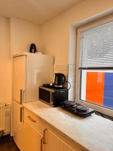 a kitchen with a microwave and a refrigerator at Donea Home Service in Schönebeck