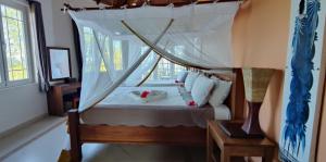 a bedroom with a bed with a canopy at Beautiful Secluded 8 bedroom Beach Villa with Pool in Makunduchi