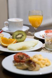 a table with plates of food and a glass of orange juice at Porcel Sabica in Granada